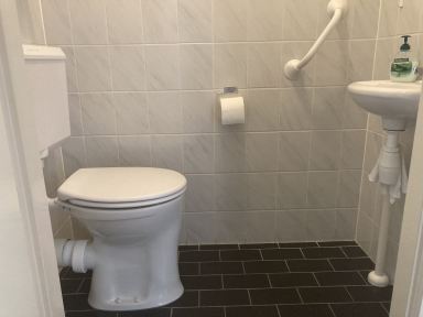 Verhoogd toilet geplaatst inclusief greep ter ondersteuning