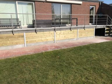 Houten wand geplaatst onder terras in Assenede