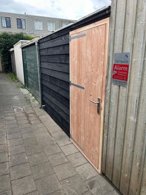 De achterzijde van een tuin in Hoofddorp is uitgerust met een nieuwe schutting en een bijpassende deur, volledig uitgevoerd in Douglas hout.