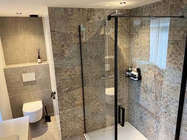 luxe badkamer ge&iuml;nstalleerd te Asten waarbij alle hoektegels in verstek zijn gezaagd zodat er geen tegelstrips nodig is.