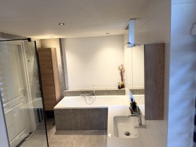 luxe badkamer ge&iuml;nstalleerd te Asten waarbij alle hoektegels in verstek zijn gezaagd zodat er geen tegelstrips nodig is.
