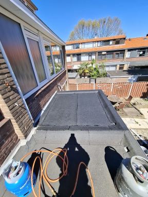 Plaatsen van een zinken dakgoot, aanbrengen van bitumen dakbedekking en het installeren van een pui.