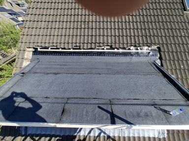 Plaatsen van een zinken dakgoot, aanbrengen van bitumen dakbedekking en het installeren van een pui.